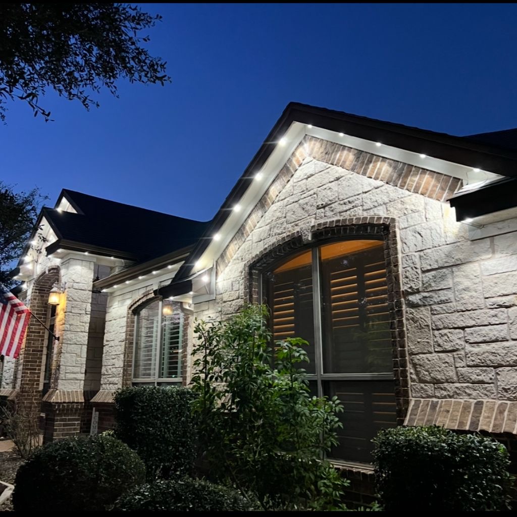 Stone and brick facade lit with cool white architectural downlights at dusk